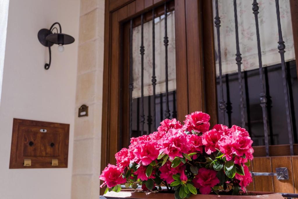 un vaso di fiori rosa davanti a una finestra di La casa di Jannina a Fasano