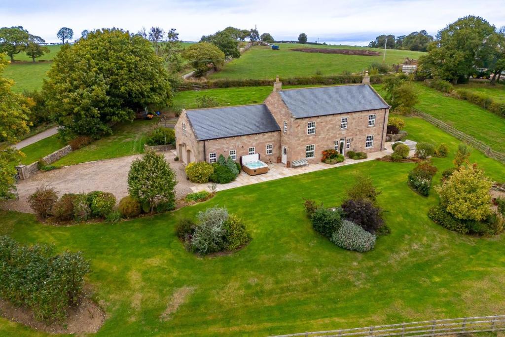 an aerial view of a brick house on a green field at Tinkers Folly in Harrogate