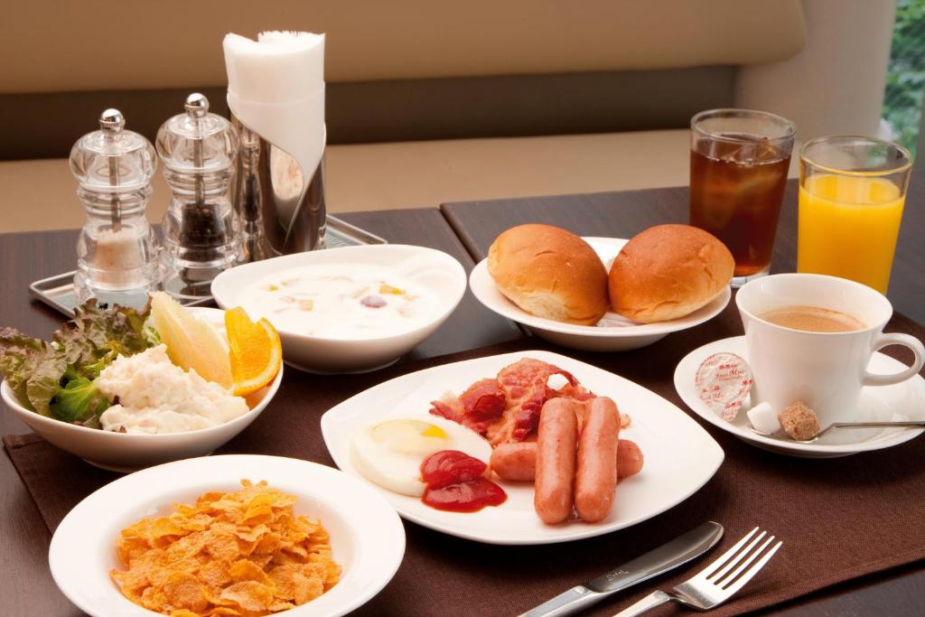 a table topped with plates of breakfast foods and drinks at Citadines Central Shinjuku Tokyo in Tokyo