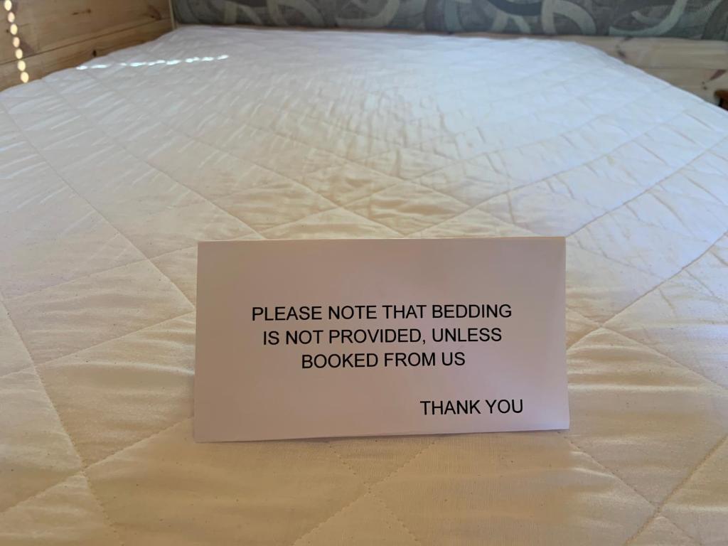 a sign sitting on top of a mattress at Poplars Farm Site Glamping Pods Adults only with separate, private shower rooms in Hulland