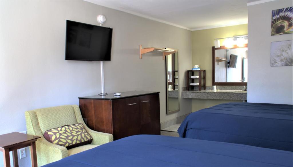 a hotel room with a bed and a television at Eastern Shore Motel in Daphne