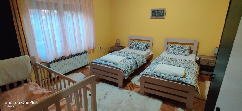a small bedroom with two beds and a window at Apartman "Dom Stankovića" in Pirot