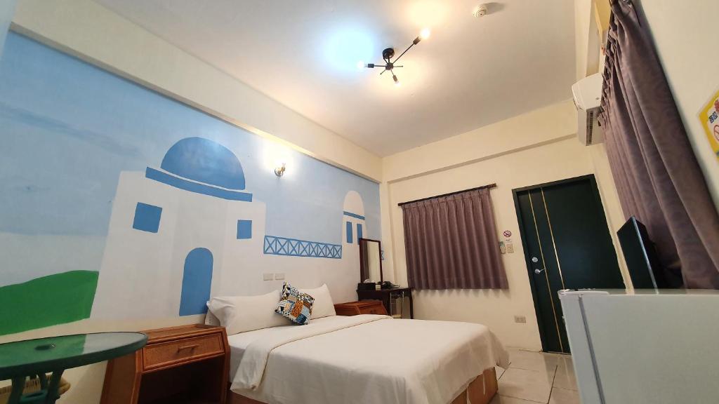 a bedroom with a bed with a lighthouse painted on the wall at Lang Jiao Ya She Homestay in Hengchun