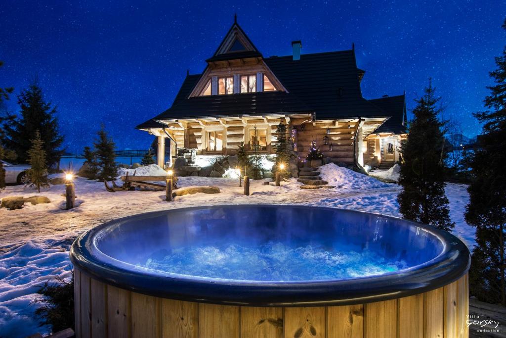 una vasca idromassaggio nella neve di fronte a una casa di Luxury Chalet Villa Gorsky Hanco & Janso a Poronin