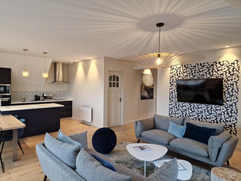 a living room with two couches and a kitchen at La touline in Concarneau