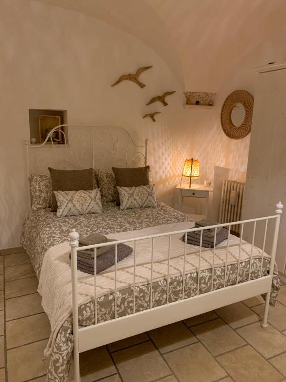una camera da letto con un letto bianco con uccelli sul muro di Impressioni in Valle D’Itria a Martina Franca
