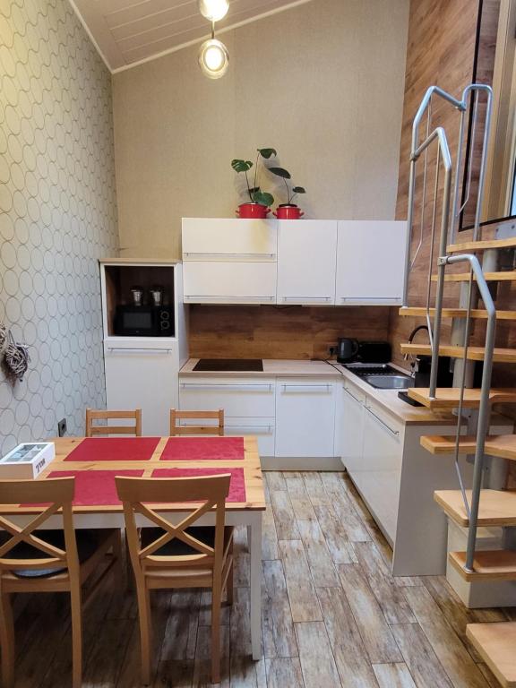 eine Küche mit weißen Schränken sowie einem Tisch und Stühlen in der Unterkunft Apartment Ferienhaus in Würzburg