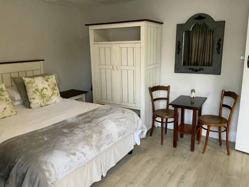 a bedroom with a bed and a table and chairs at La Roche Stay in Port Elizabeth