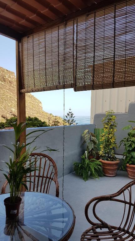una mesa y sillas en un patio con vistas al océano en Casa Tortuga, en Santa Cruz de Tenerife