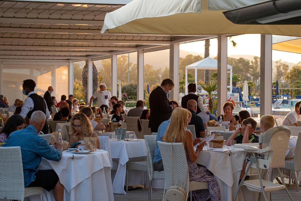 a group of people sitting at tables in a restaurant at Hotel Airone isola d'Elba in Portoferraio