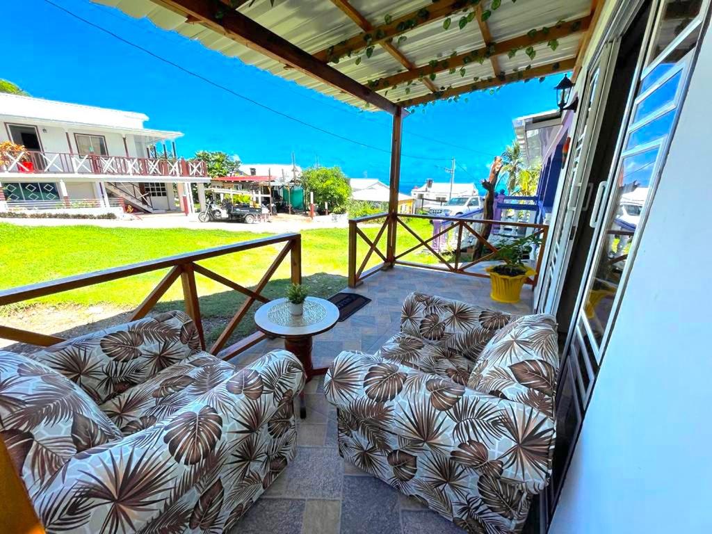 een patio met banken en een tafel op een balkon bij POSADA VILLA BRYAN in Providencia