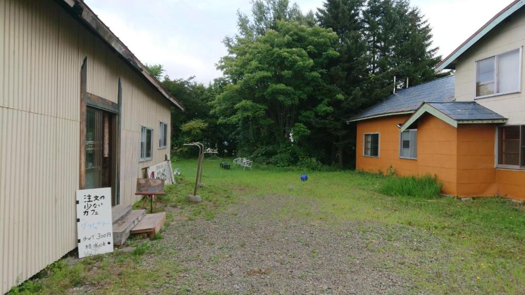 einen Hof neben einem Gebäude mit einem Schild daneben in der Unterkunft Daramusara - Vacation STAY 13520 in Furano