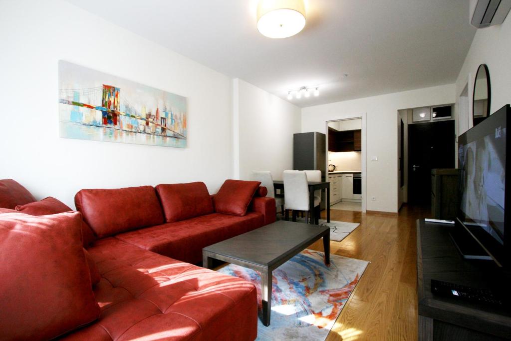 ein Wohnzimmer mit einem roten Sofa und einem Tisch in der Unterkunft Apartment Iva in Belgrad