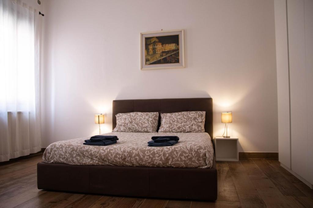 1 dormitorio con 1 cama con 2 lámparas en Beocio Home • The hidden gem in Murano’s heart, en Murano