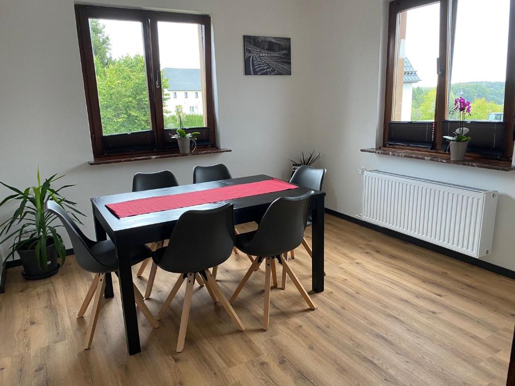 a dining room with a black table and chairs at Ringtoys Rooms in Welcherath