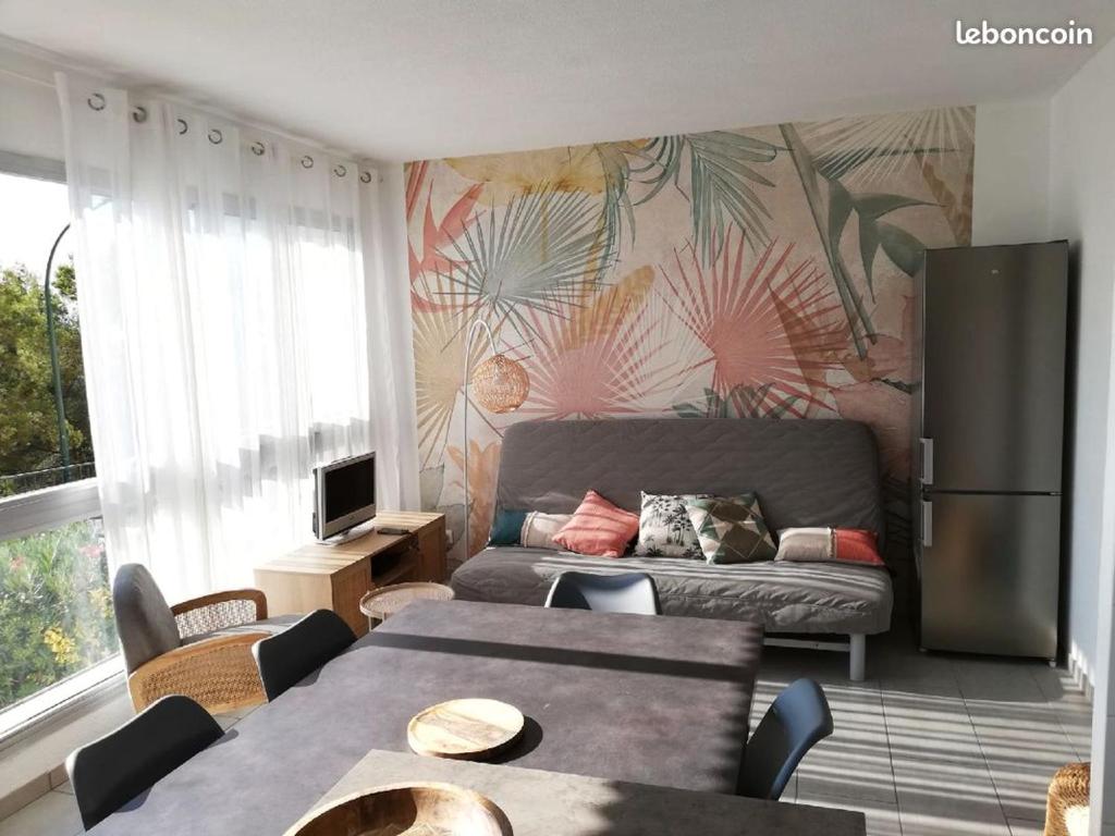 - un salon avec un canapé et un réfrigérateur dans l'établissement Appartement de charme Saint Mandrier sur Mer, à Saint-Mandrier-sur-Mer