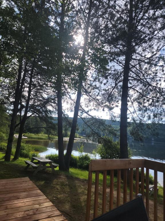 a wooden deck with a view of a lake at Alison A Romantic Getaway With Private Hot Tub in Rivière-Rouge