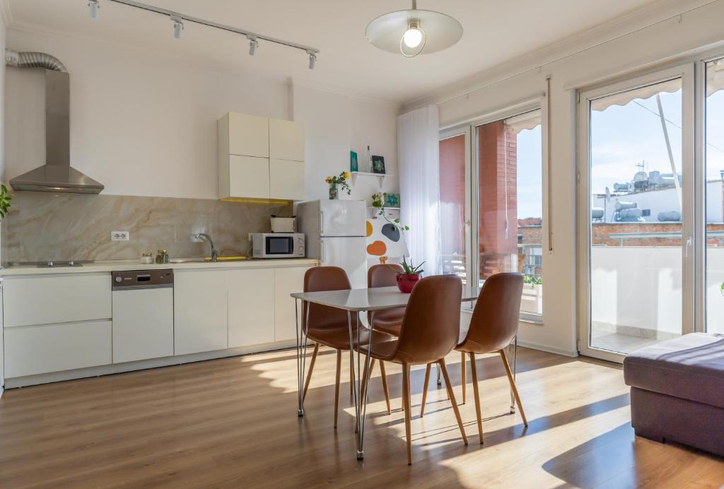 cocina y comedor con mesa y sillas en New Apartament, en Tirana