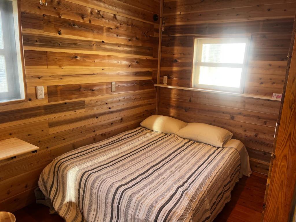 1 dormitorio con 1 cama en una habitación de madera en Glamping Village Leaf - Vacation STAY 65726v, en Mashiki