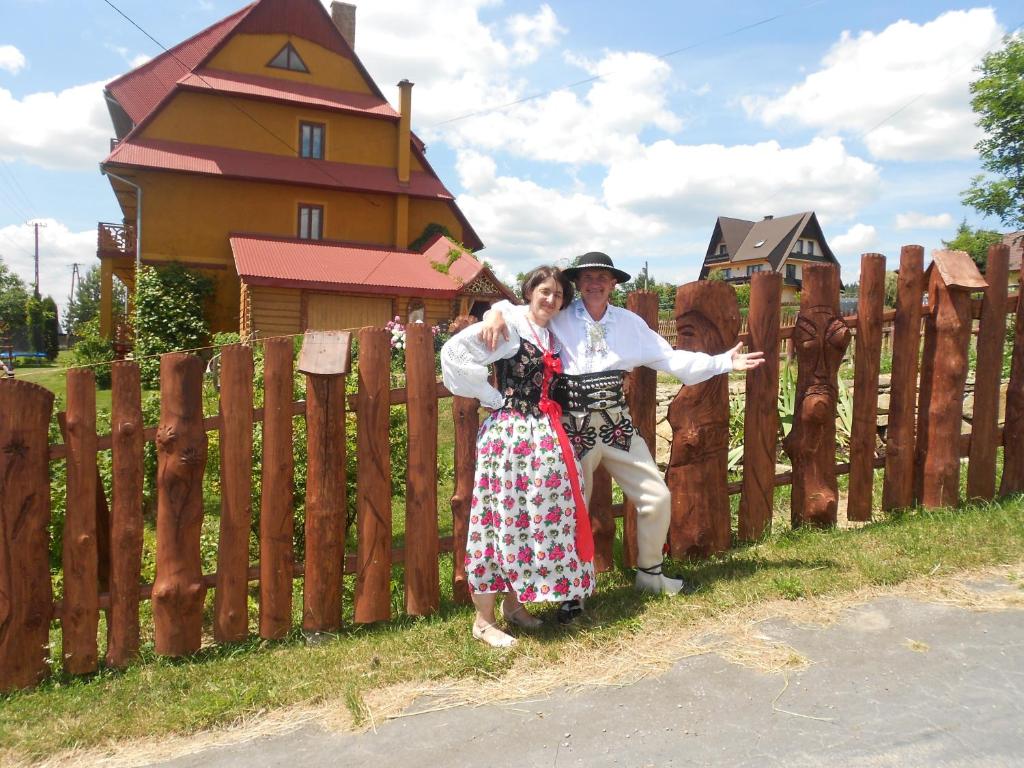 un homme et une femme debout à côté d'une clôture dans l'établissement Gospodarstwo Karolina, à Huba
