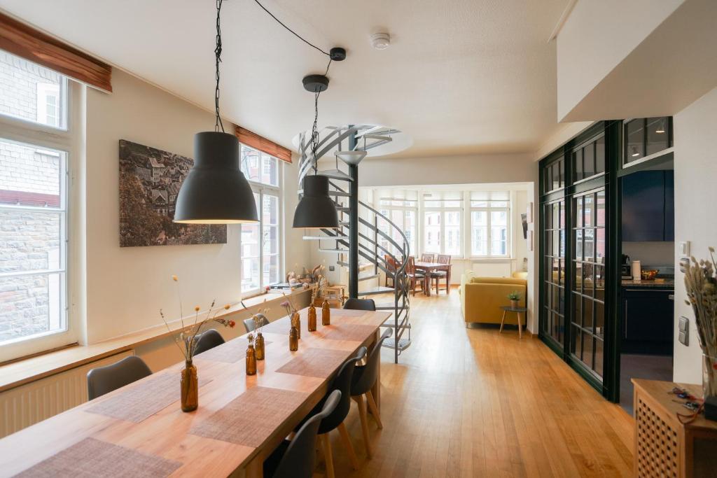 een eetkamer met een lange tafel en stoelen bij LOFT13 Traumhafte Wohnung mit Terrasse für 8 Gäste in Monschau
