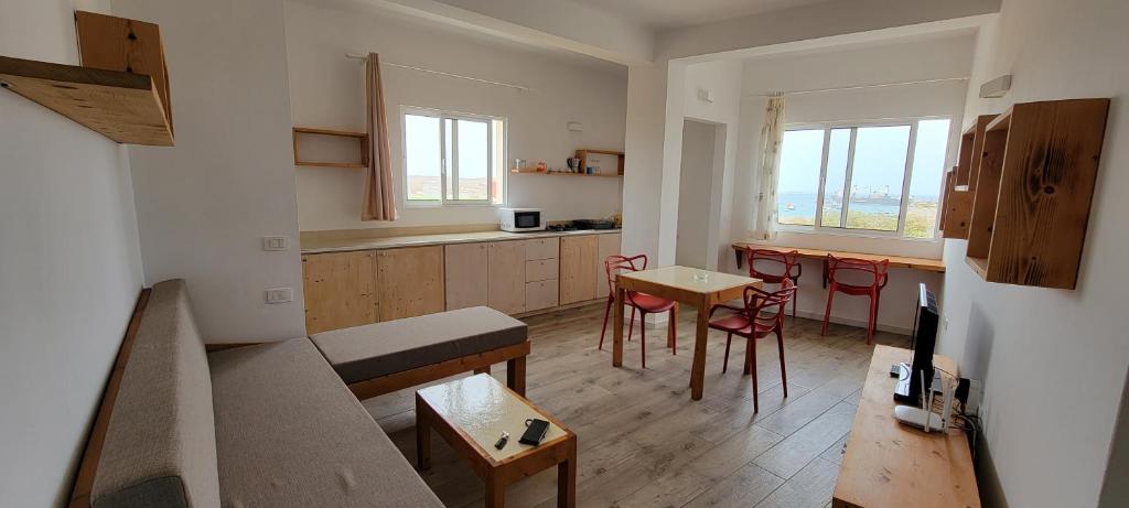 sala de estar con cocina, mesa y sillas en Baia Palmeira Residence, en Palmeira