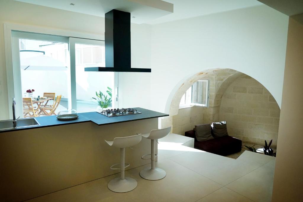 a kitchen with a counter with a bar stool in a room at Miro Luxury Home in San Vito dei Normanni