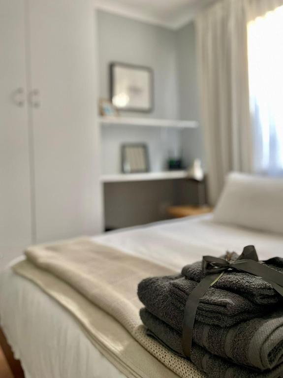 a pile of towels sitting on top of a bed at Milnerton Cottage in Cape Town