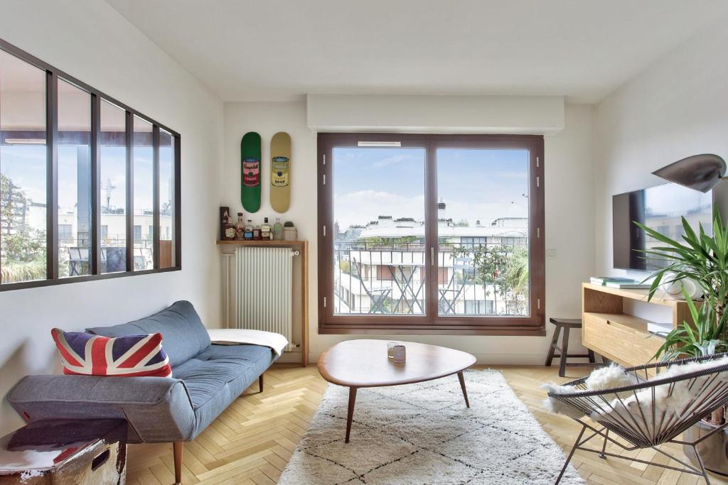 un salon avec un canapé et une table dans l'établissement Appartement Doumer et son balcon - Welkeys, à Paris