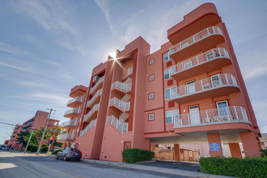 Un bâtiment orange avec une voiture garée devant. dans l'établissement Americana Princess Suites/Condos, à Ocean City