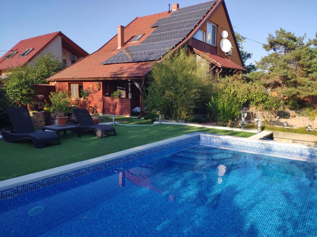 a house with a swimming pool in front of a house at Karolina Apartment in Békéscsaba