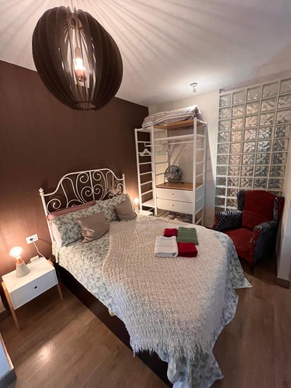 ein Schlafzimmer mit einem Bett und einem roten Stuhl in der Unterkunft Dream Central Toscal in Santa Cruz de Tenerife