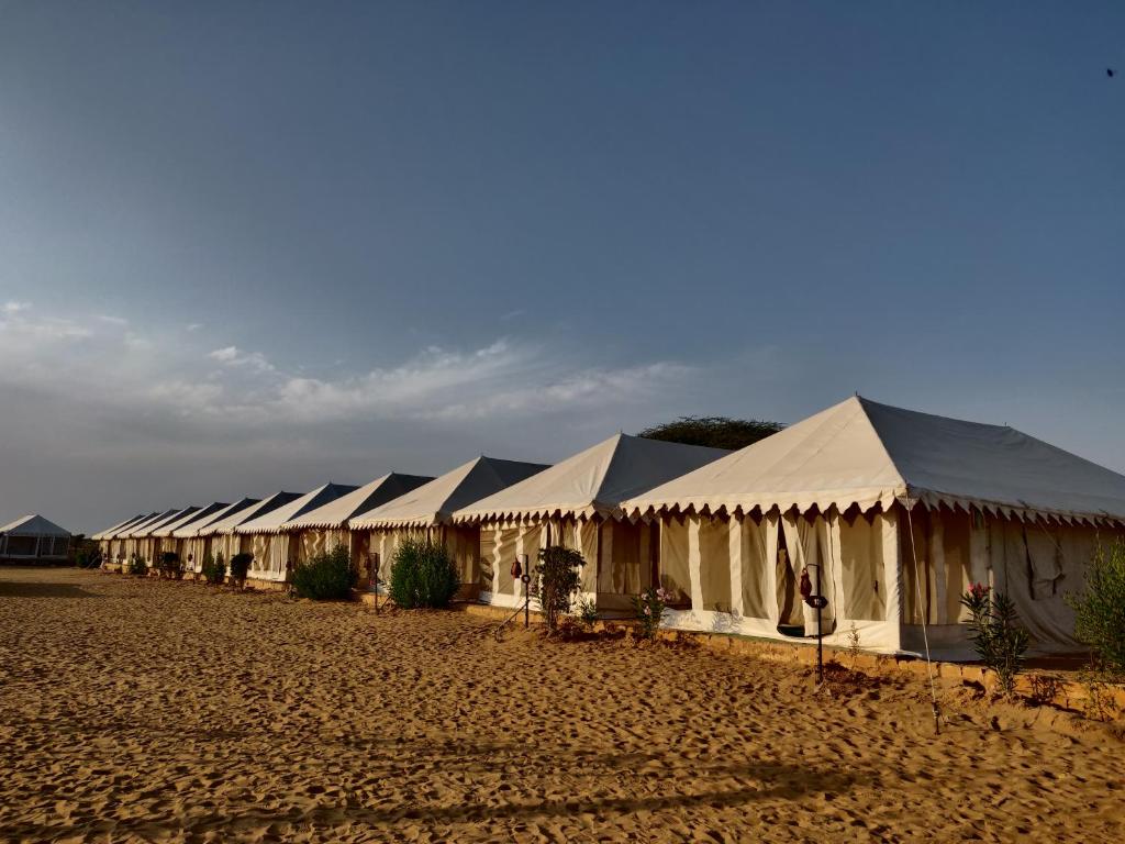 a row of tents in a field in a desert at Nagina Desert Camp in Sām