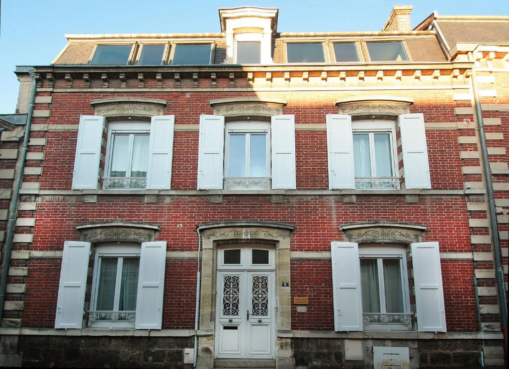 a red brick building with white windows and a door at Chambre D'hôtes Les Epicuriens in Épernay