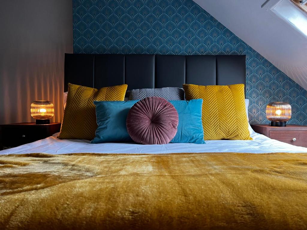 a large bed with a black headboard and colorful pillows at Woodquay House in Galway