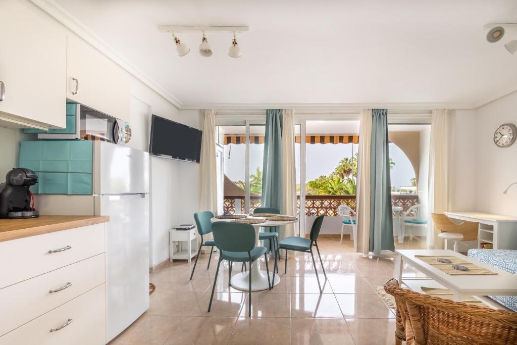 a kitchen and dining room with a table and chairs at Flamingo Apartment on the south near the beach in Palm-mar
