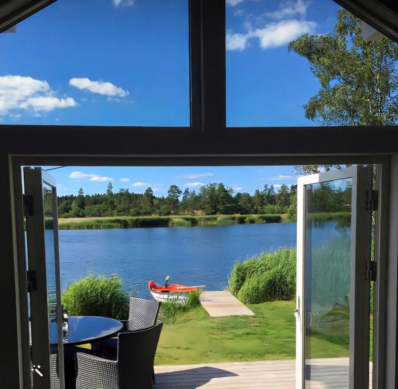 een raam met uitzicht op een meer vanuit een huis bij Strandstugan, Solviken in Rockneby