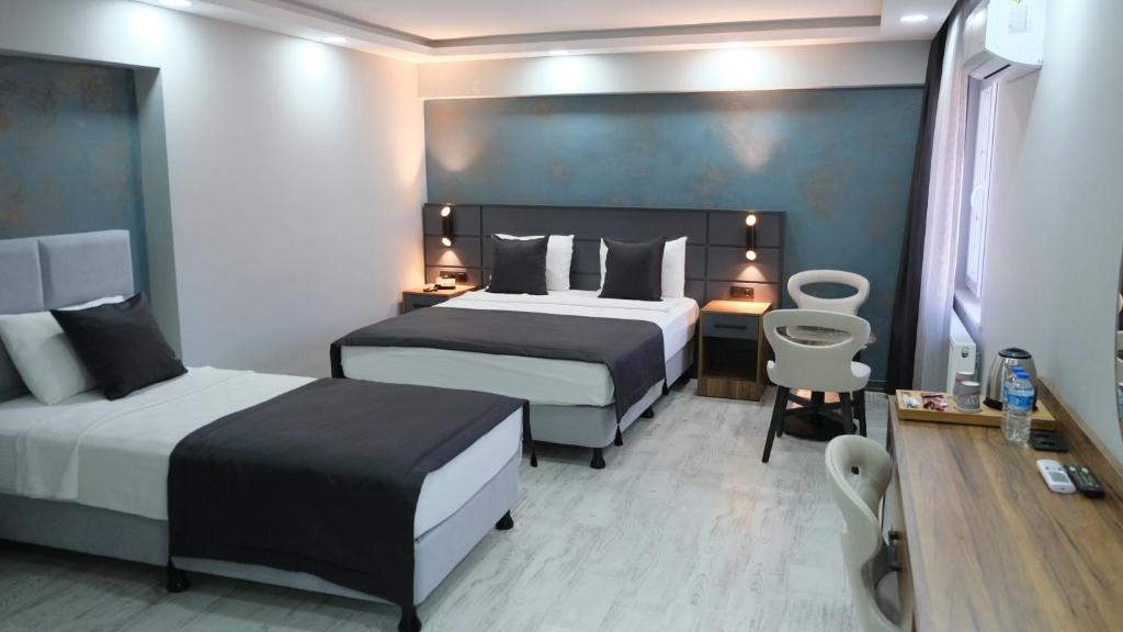 a hotel room with two beds and a desk at Lagom Hotel in Edirne