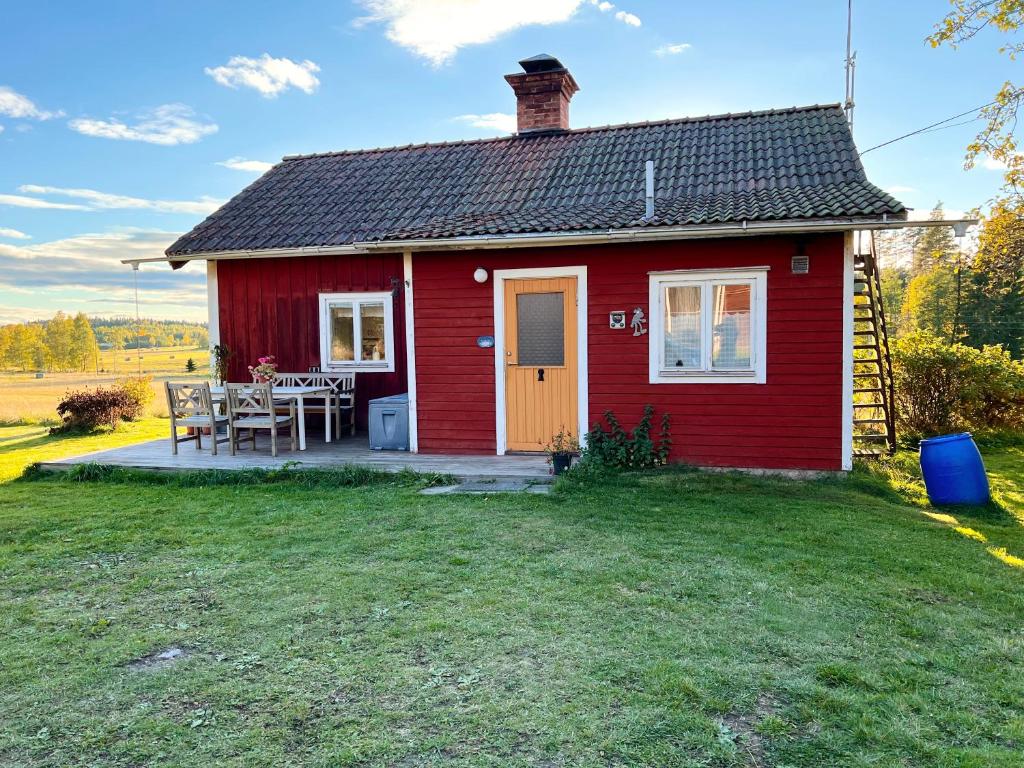 MöklintaにあるAldermyran - 1800-talstorp i Möklintaの芝生の上にテーブルを置いた赤い家