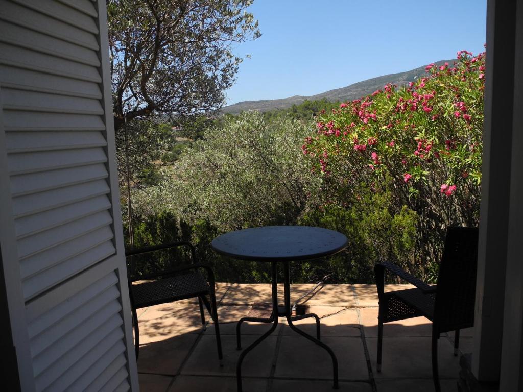 a table and chairs on a patio with flowers at Tranquilos estudios cerca de la playa in Cadaqués