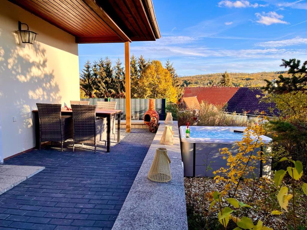 un patio con una mesa y una piscina en Ferienhaus Harzblick, en Meisdorf