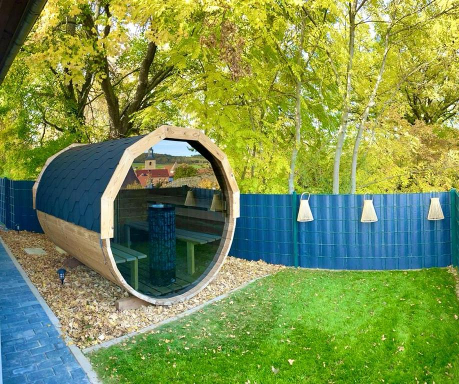 a circular building with a mirror in the grass at Ferienhaus Harzblick in Meisdorf