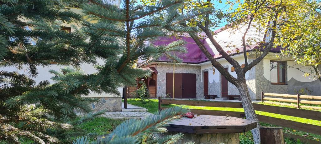 a house with a picnic table in front of it at Usadba Okhotnichiy Dvor in Yabluniv