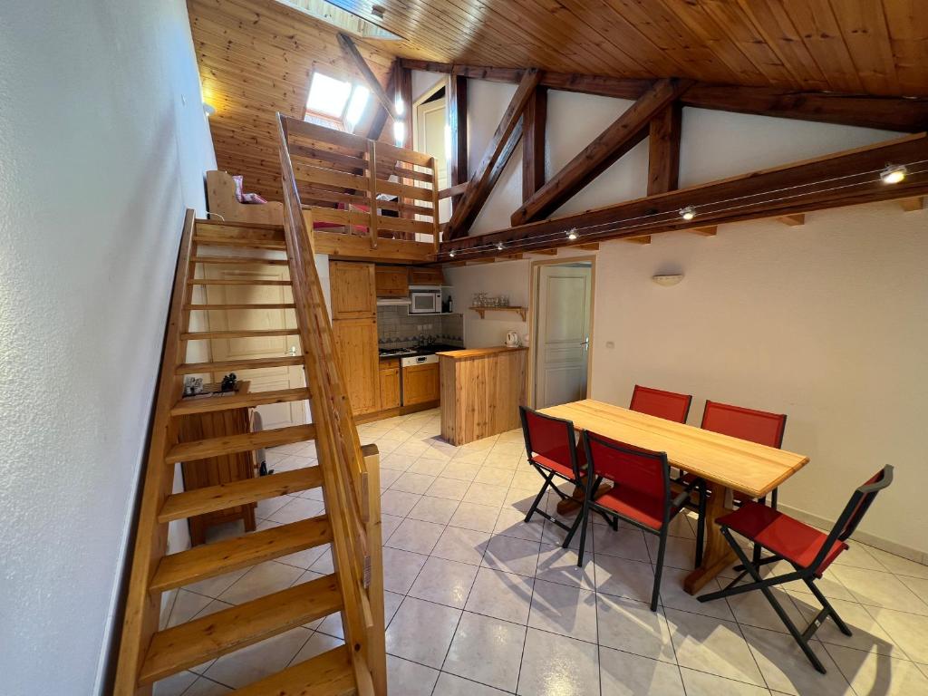 a kitchen and dining room with a wooden table and chairs at Charmant duplex pied de pistes Briançon in Briançon