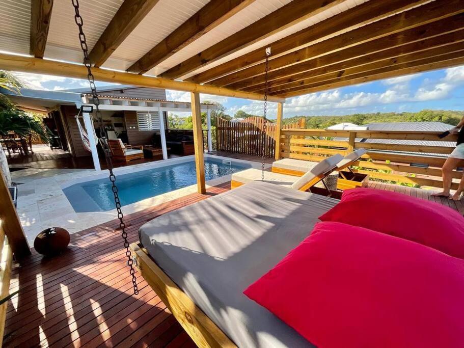 un letto a dondolo su un ponte accanto a una piscina di Villa Titi a Saint-François