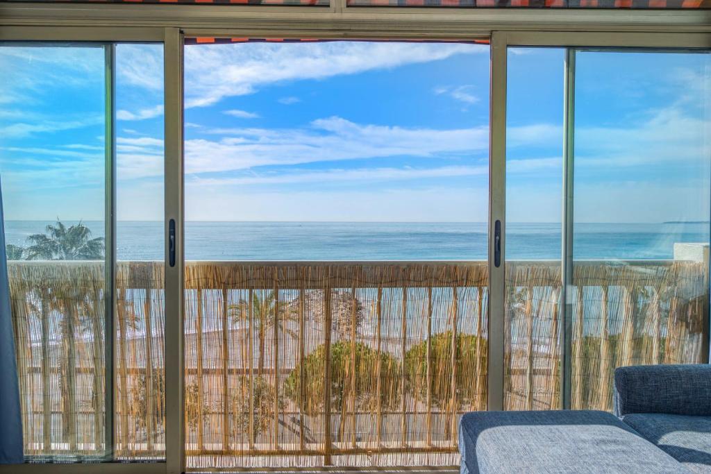 - une vue sur l'océan depuis la fenêtre du salon dans l'établissement Appartement Rivage - Welkeys, à Cagnes-sur-Mer