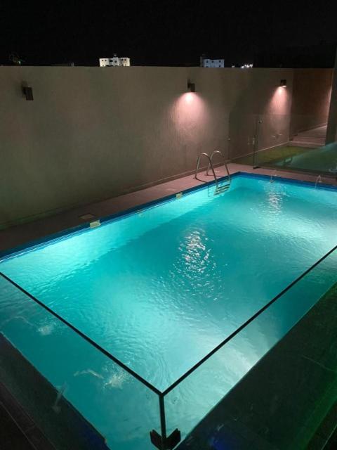 فلل وشاليهات Shali الفندقية في السيل الصغير: حمام سباحة كبير في الليل مع إضاءة زرقاء