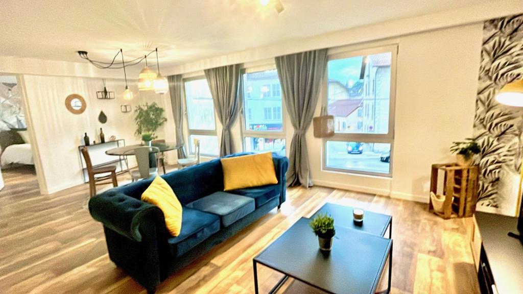 sala de estar con sofá azul y mesa en Appartement 2 chambres avec parking, en Pontarlier