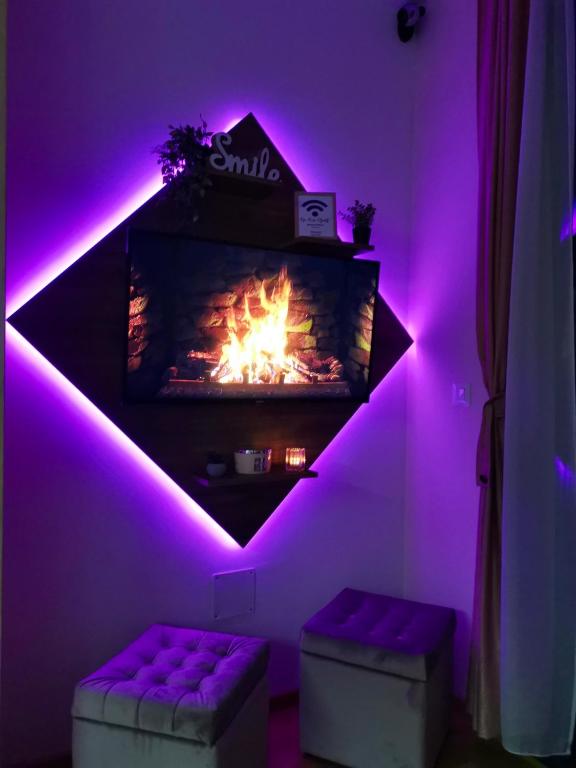 a living room with a fireplace with purple lights at Apartman M2 Titova Vila in Palisat