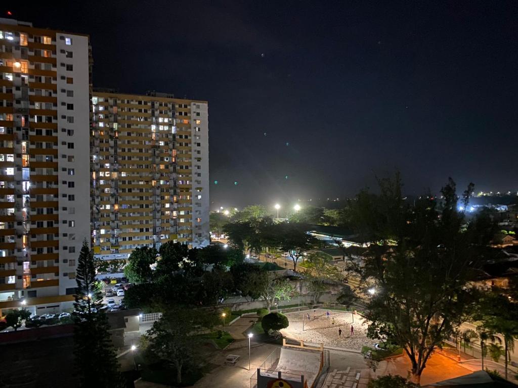 Apartamento Temporada Barra da Tijuca في ريو دي جانيرو: اطلاله على مدينه بالليل بالمباني